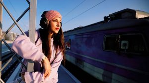 Teenager hängt am Bahnsteig ab und beobachtet vorbeifahrenden Zug