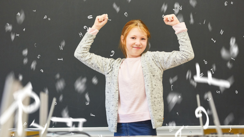 Mädchen in Grundschule jubelt vor Tafel