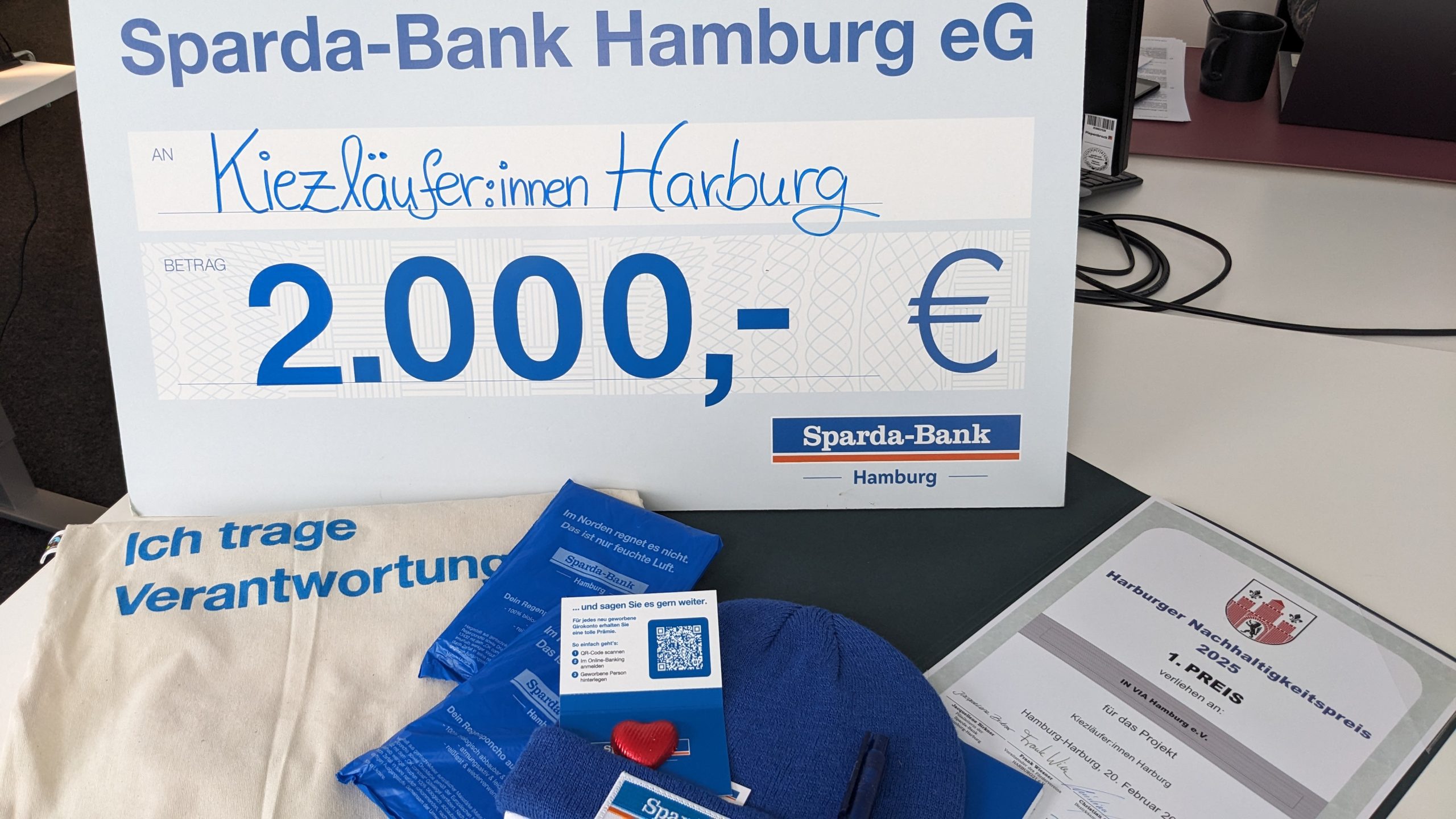 Scheck von der Sparda-Bank für die Kiezläufer:innen in Höhe von 2000€